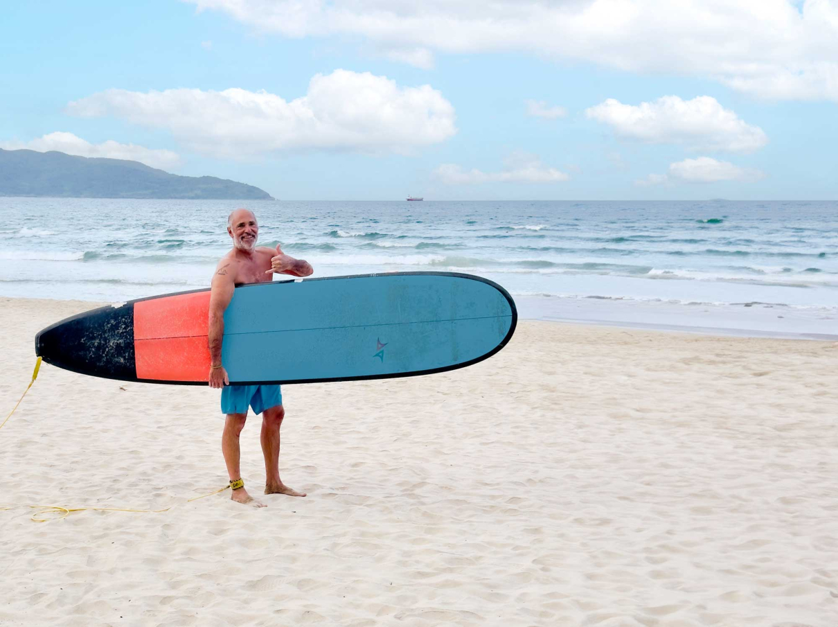 Joakim Lloyd Rabff holding a surfboard in Da Nang, Vietnam in October 2023.