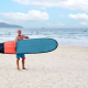 Joakim Lloyd Rabff holding a surfboard in Da Nang, Vietnam in October 2023.